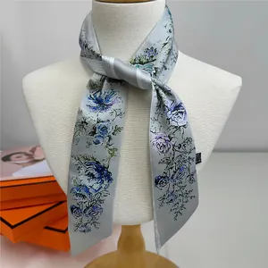 Detail of light blue floral silk scarf with rose patterns tied on a model's neck