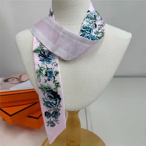 Detail of pink floral silk twilly scarf styled on a mannequin with elegant patterns