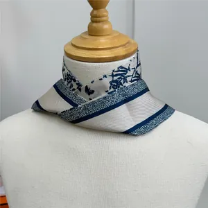 Close-up of silk-textured twill scarf with navy floral patterns on a mannequin stand