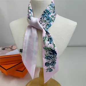Detail of pink floral satin twilly scarf tied on mannequin neck with rose patterns