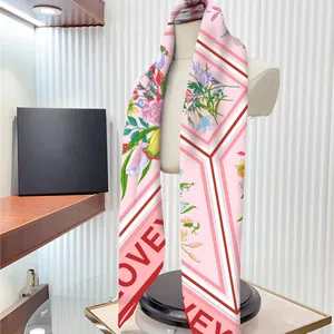Sciarpa di seta rosa con motivi floreali e testo LOVE su manichino bianco