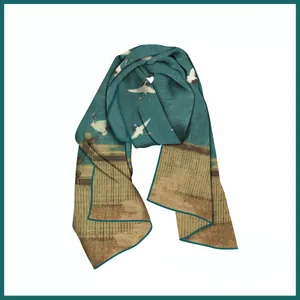 Detail of teal and gold silk scarf featuring elegant crane and oriental architecture
