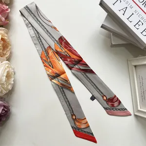 Close-up of printed silk twilly scarf with vintage chain patterns on a soft background