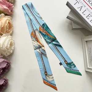Detail of elegant sky blue printed twilly scarf with chain patterns and fabric label