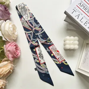Detail eines dunkelblauen Twilly-Schals mit Pokermustern auf weißem Dekotisch