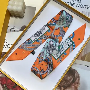Eleganter orangefarbener Seidenschal mit Spielkartenmotiven in einer gelben Geschenkbox