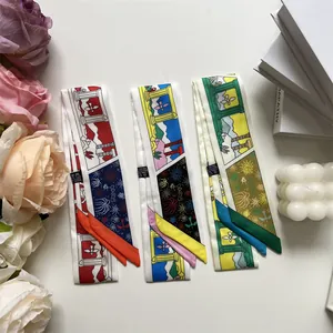 Detalle de pañuelos twilly con patrones y etiqueta de lavado para accesorios de bolsos