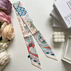 Detalle de una bufanda twilly delgada y colorida con patrones de mariposas y corazones