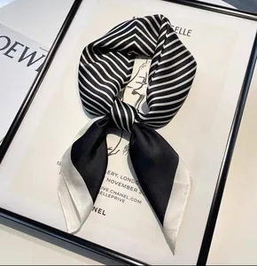 Detailed shot of striped black and white silk neck scarf in an elegant knotted styling