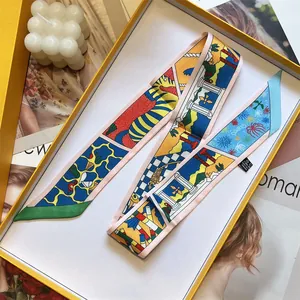 Detalle de un pañuelo de seda con estampado artístico en una caja de regalo naranja de lujo