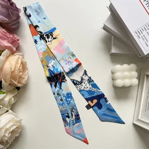 Detail of a silky narrow scarf with dog illustrations and elegant floral decorations