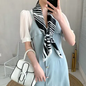 Detail of elegant black and white striped silk scarf paired with a light blue puff sleeve dress