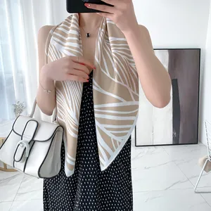 Detail of silk-like twill scarf with abstract leaf print styled on an elegant outfit