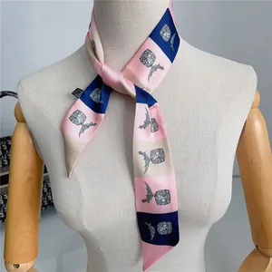 Macro-opname van een smalle twilly sjaal met roze ruitpatroon en handgeschilderde ananas
