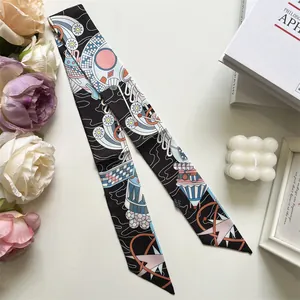 Détail d'un foulard étroit en soie noire avec des motifs célestes et géométriques colorés