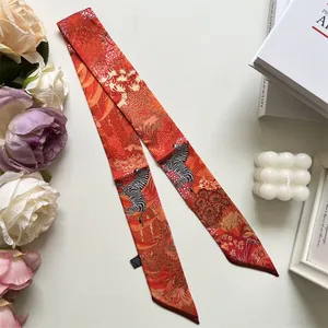 Detail of orange and red long narrow silk scarf with zebra and jungle floral pattern