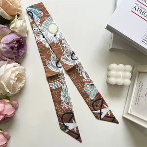 Détail macro d'un foulard en soie aux motifs célestes noué sur une surface blanche