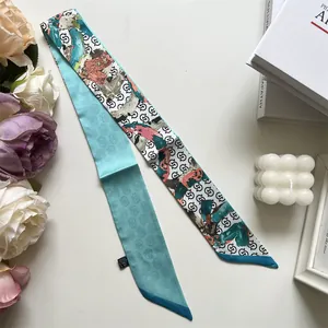Detail eines doppelseitigen schmalen Seidenschals mit Blumendruck und blauem Farbmuster