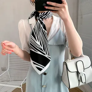 Elegant black and white printed silk scarf paired with a white shirt for a chic look