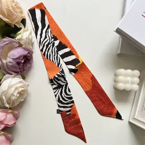 Detail of zebra pattern and orange feather print on high-end narrow silk twilly scarf
