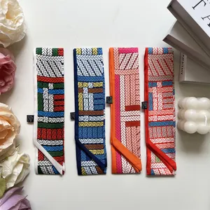 Flat lay of colorful twill silk scarves with knot patterns and rose decor