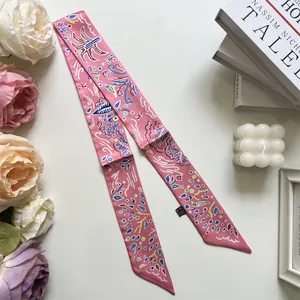 Detail of pink narrow silk scarf with abstract patterns, styled with candles and flowers
