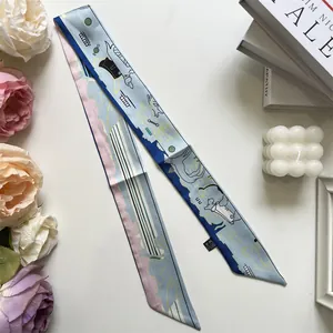 Detail eines hellblauen schmalen Seidenschals mit Hundemotiv und eleganten Blumen-Requisiten