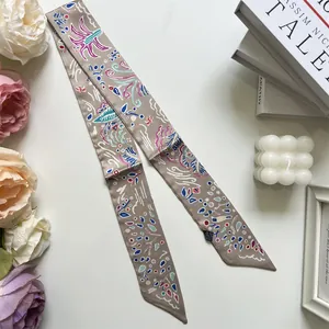 Close-up of pink champagne silk twilly scarf with abstract art prints on white background