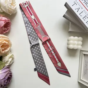 Detailed flat lay of pink polyester twilly scarf with polka dots and buckle pattern