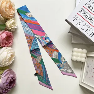 Detalle de un pañuelo twilly de satén con estampados geométricos y logotipo de París