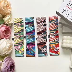 Detail of colorful silk twilly scarves with geometric patterns and Paris labels on white