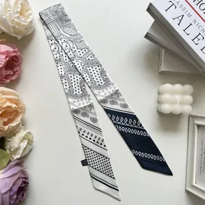 Detail of a black and white twilly scarf featuring polka dots and paisley patterns