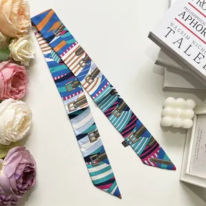 Flat lay of a stylish satin twilly scarf with colorful prints and floral decorations