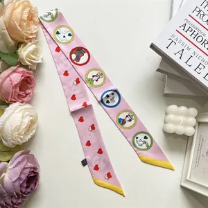 Detail shot of a pink silk-like scarf with red hearts and storybook illustrations