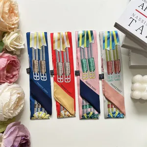 Flat lay of colorful French twilly scarves with equestrian prints and floral decor