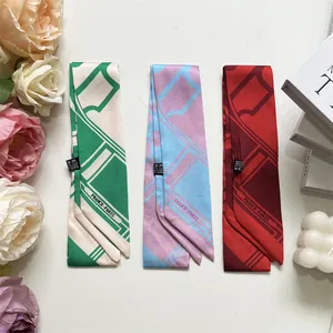 Dettaglio di tre sciarpe twilly con stampe geometriche e decorazioni floreali eleganti