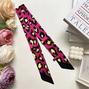 Dettaglio della sciarpa in raso maculato con petali di rosa su sfondo bianco