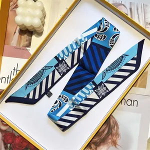 Elegant long silk twilly scarf with blue floral patterns in a luxury display box