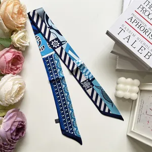 Detail of blue and white geometric twilly scarf with wave and star patterns for women