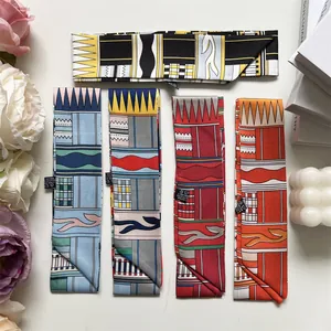 Détail à plat de longs foulards en soie aux motifs géométriques colorés sur bureau