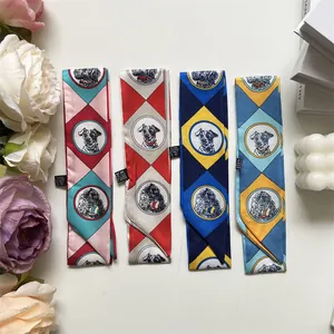 Détail de quatre écharpes en soie imprimées double face avec des motifs de chiens variés