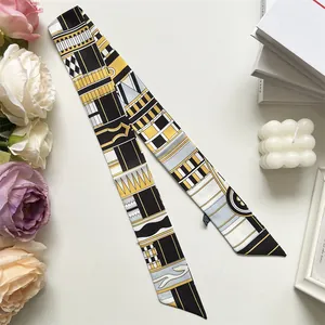 Vue détaillée du foulard en soie style français aux motifs géométriques noir blanc et or