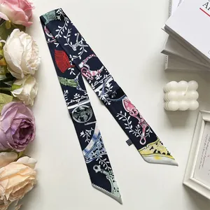 Detail van elegante zijden sjaal met vogel- en bloemmotieven op een witte achtergrond