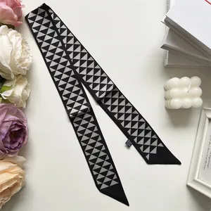 Detailopname van een zijden sjaal met geometrische driehoekprint en schuine uiteinden