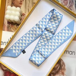 Smal twilly sjaaltje met blauw en wit driehoekig patroon in een luxe geschenkdoos