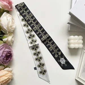 Detail of double-sided silk Twilly scarf with gold rope pattern and elegant Paris motif