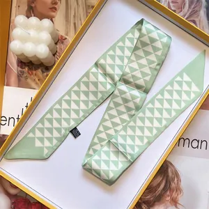 Smalle kunstzijden sjaal met groen en wit geometrisch patroon in een geschenkdoos