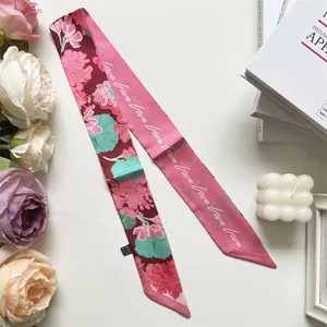 Détail d'un foulard en soie double face avec imprimé floral et lettrage LOVE manuscrit