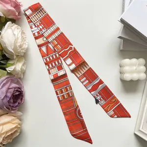 Détail d'un foulard étroit en soie à imprimé géométrique orange avec étiquette d'entretien