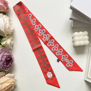 Detail of red silk twilly with rope knot print, France Paris logo, and luxury texture